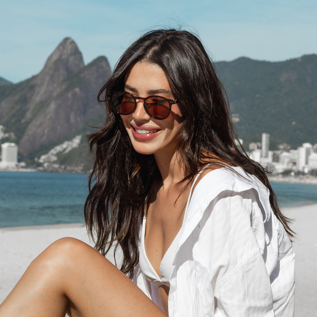Mulher sorrindo na praia usando óculos Grove de sol polarizado Fozoco